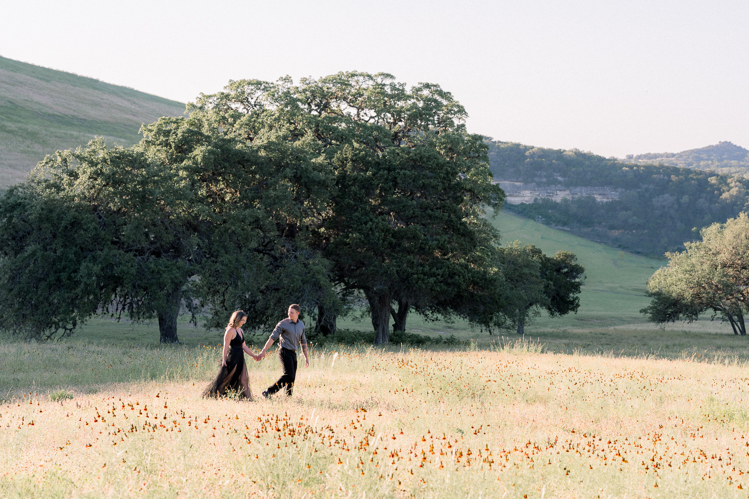 guy leading girl through open flower field in texas